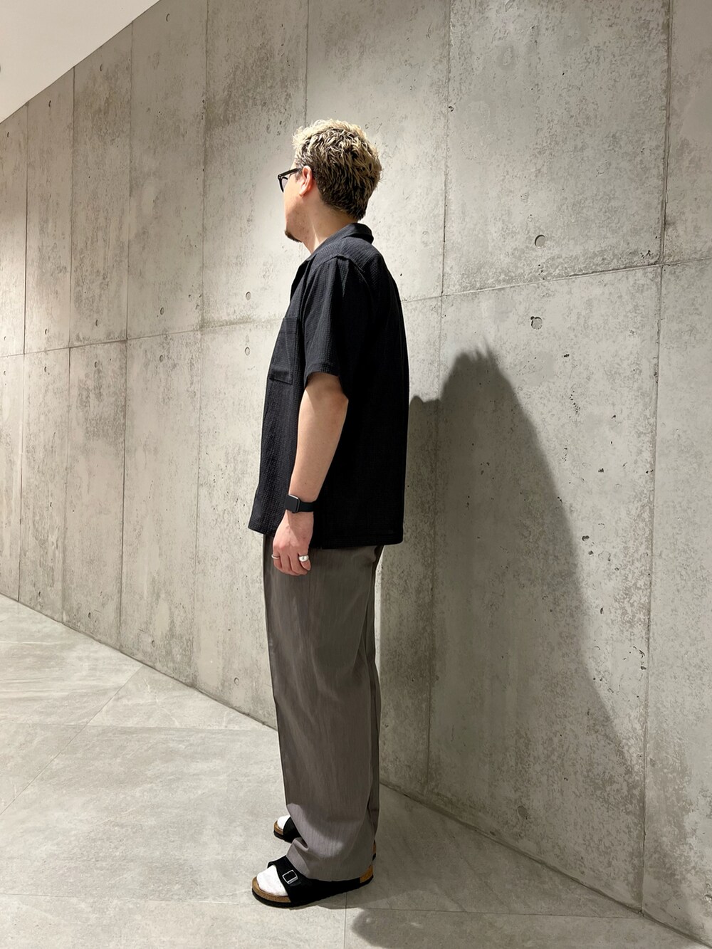 ブラック系のショルダーバッグ、グレー系のシャツ/ブラウス、ホワイト系のTシャツ/カットソーを着用したメンズの夏コーディネートの3枚目の写真