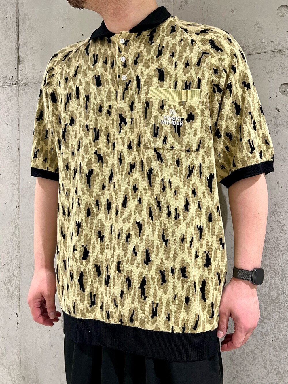 グリーン系のポロシャツ、ブラック系のその他パンツ、ブラック系のスニーカーを着用したメンズの春コーディネートの4枚目の写真