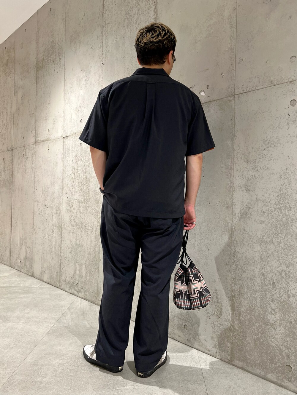 ホワイト系のスニーカー、ブラック系のシャツ/ブラウス、オレンジ系のTシャツ/カットソーを着用したメンズの夏コーディネートの4枚目の写真