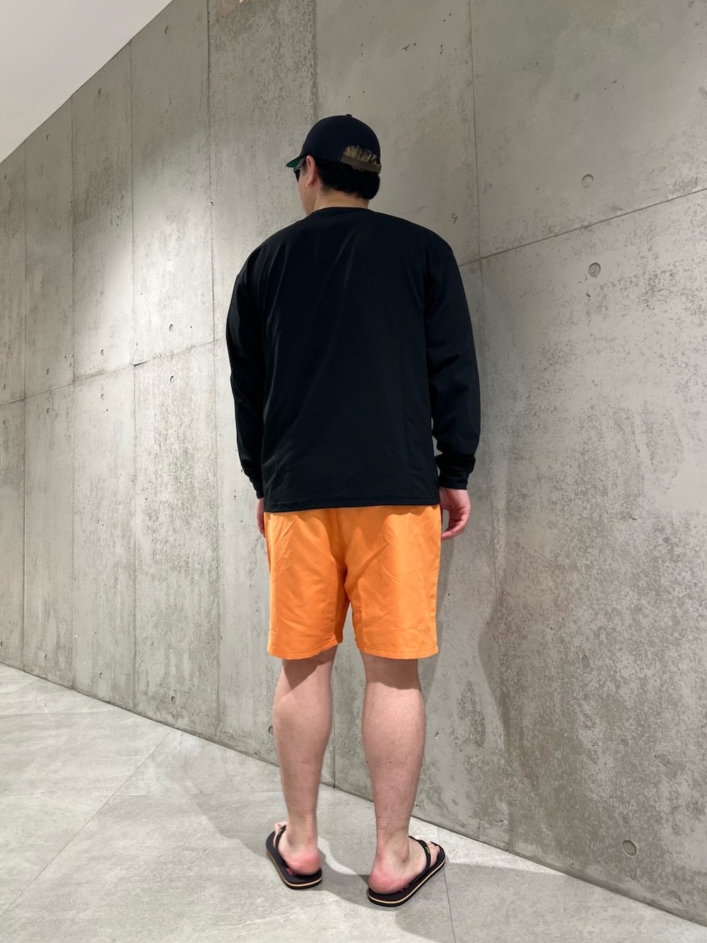 ブラック系のTシャツ/カットソー、オレンジ系のその他パンツ、ブラック系のサンダルを着用したメンズの夏コーディネートの3枚目の写真