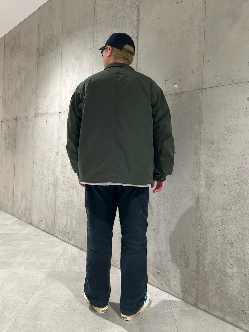 グリーン系のダウンジャケット/コート、ホワイト系のTシャツ/カットソー、ブルー系のスニーカーを着用したメンズの冬コーディネートの3枚目の写真