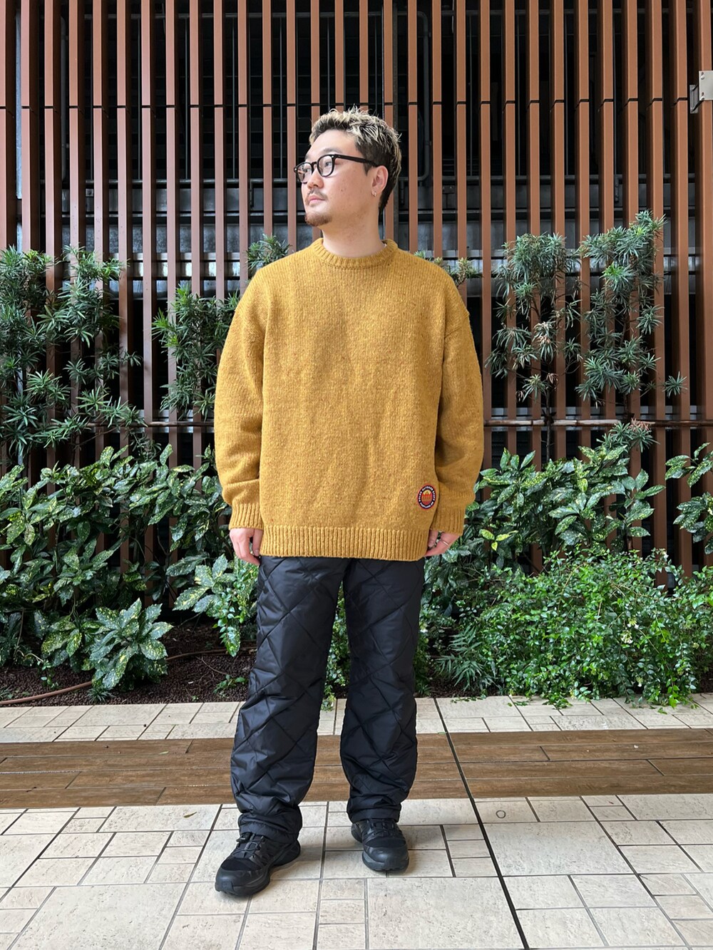 ブラック系のベスト、イエロー系のニット/セーター、ブラック系のその他パンツを着用したメンズの冬コーディネートの2枚目の写真