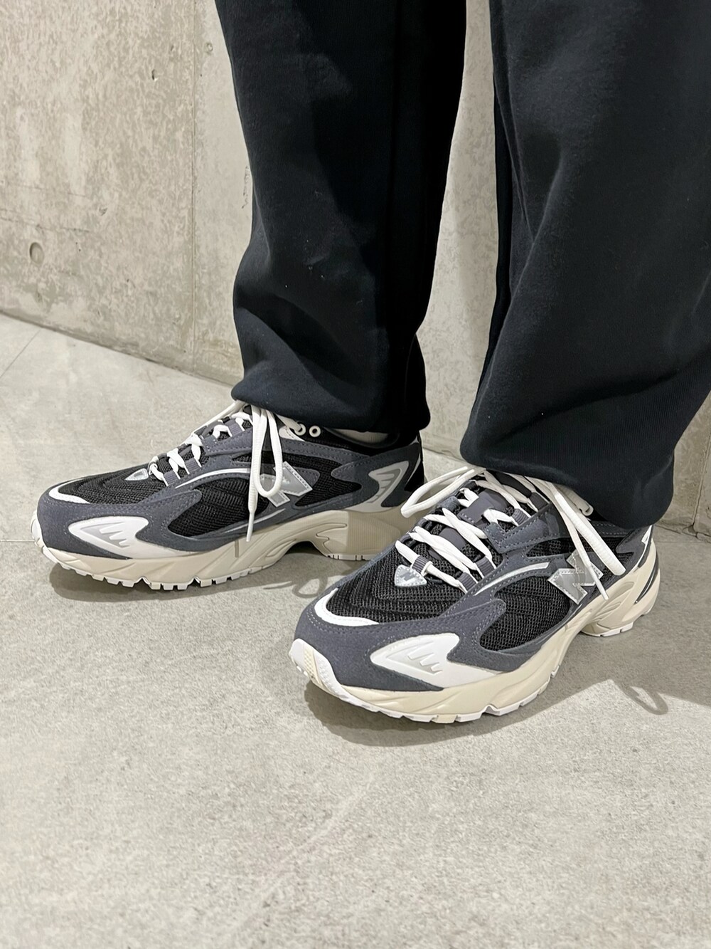 グリーン系のナイロンジャケット、ブラック系のスニーカー、ブラック系のスウェットパンツを着用したメンズの春コーディネートの5枚目の写真