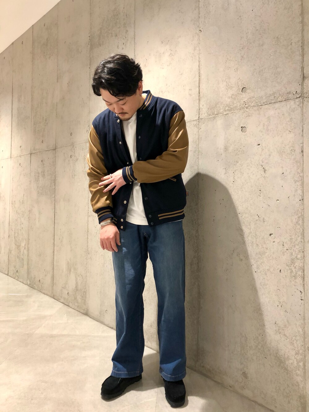 ホワイト系のTシャツ/カットソー、ブルー系のデニムパンツ、ブラック系のブーツを着用したメンズの秋コーディネートの3枚目の写真