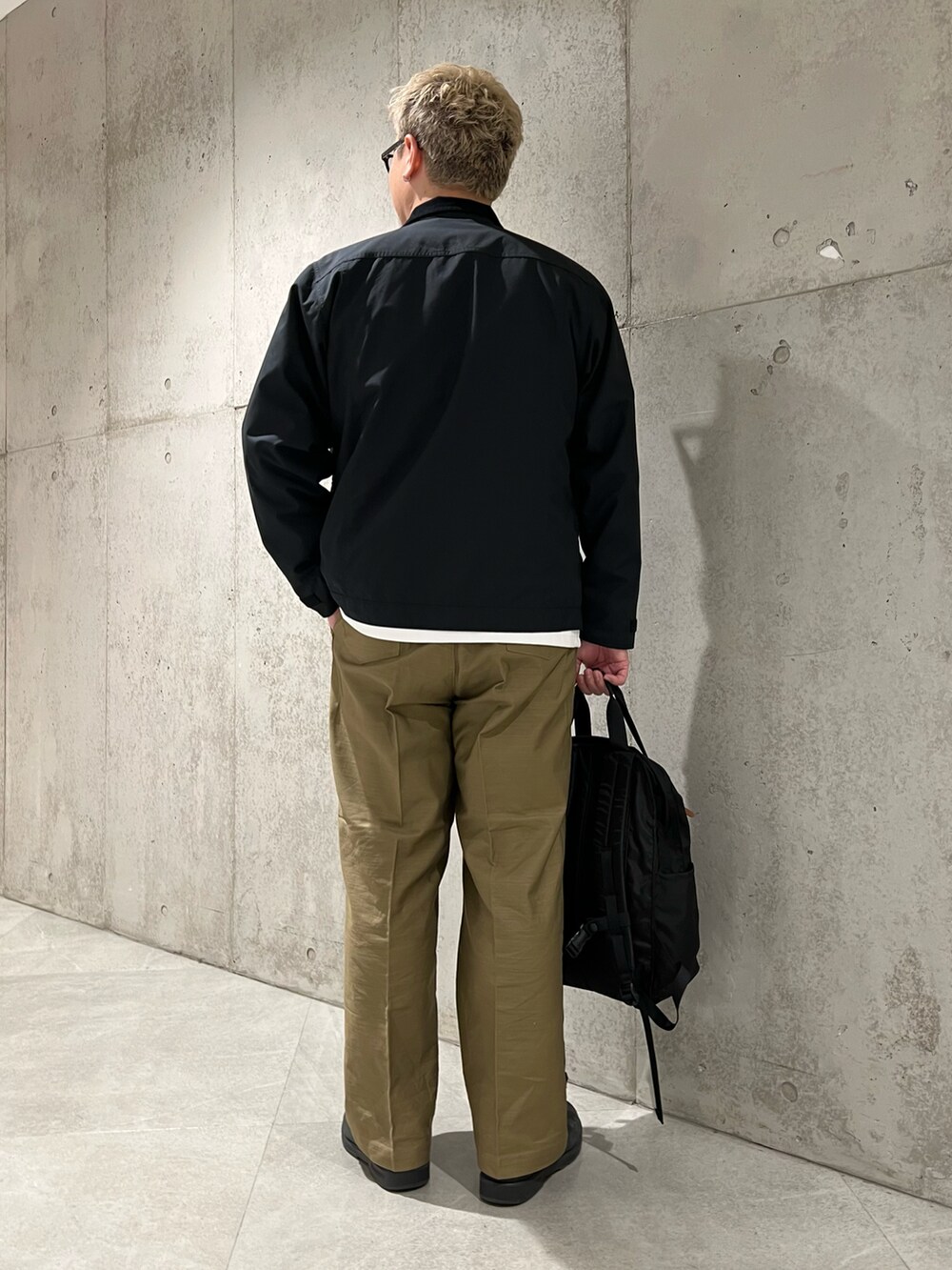 ブラック系のその他アウター、ホワイト系のTシャツ/カットソー、ブラック系のバックパック/リュックを着用したメンズの秋コーディネートの5枚目の写真