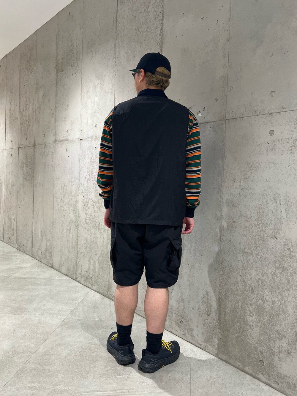 グリーン系のTシャツ/カットソー、ブラック系のベスト、ブラック系のその他パンツを着用したメンズの夏コーディネートの4枚目の写真