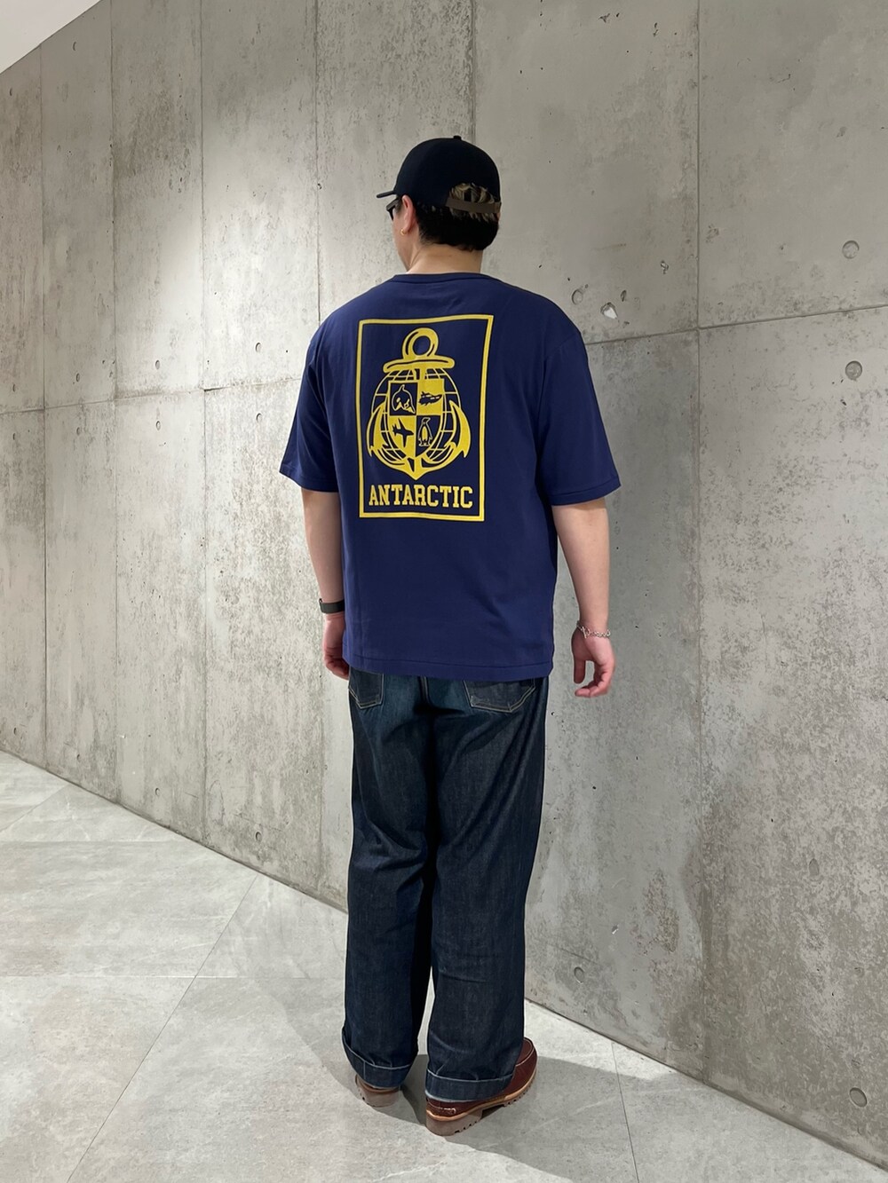 ブルー系のTシャツ/カットソー、ブルー系のデニムパンツ、レッド系のモカシン/デッキシューズを着用したメンズの春コーディネートの2枚目の写真