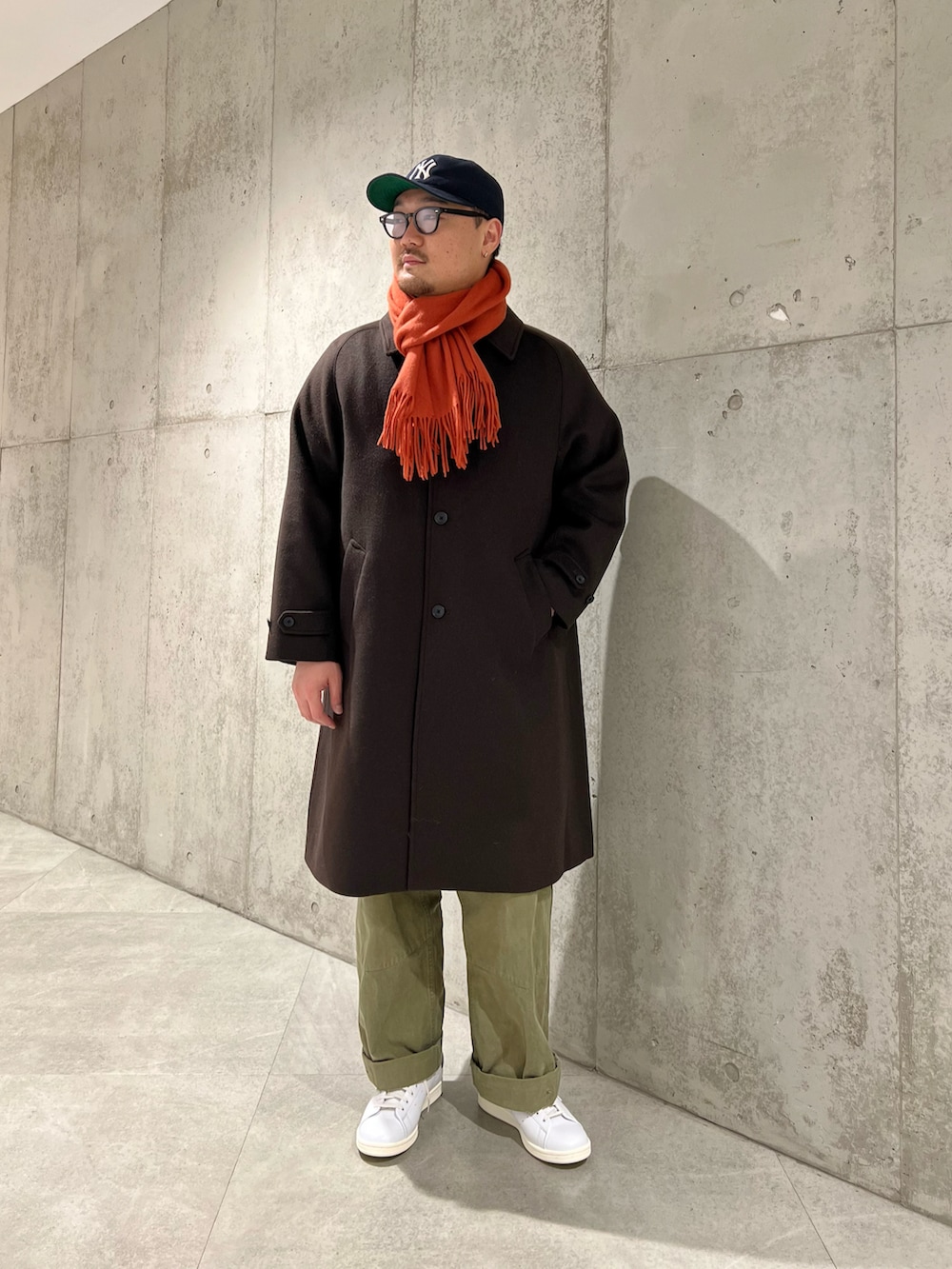 ホワイト系のスニーカー、ブラウン系のその他アウター、ブラウン系のニット/セーターを着用したメンズの冬コーディネートの2枚目の写真
