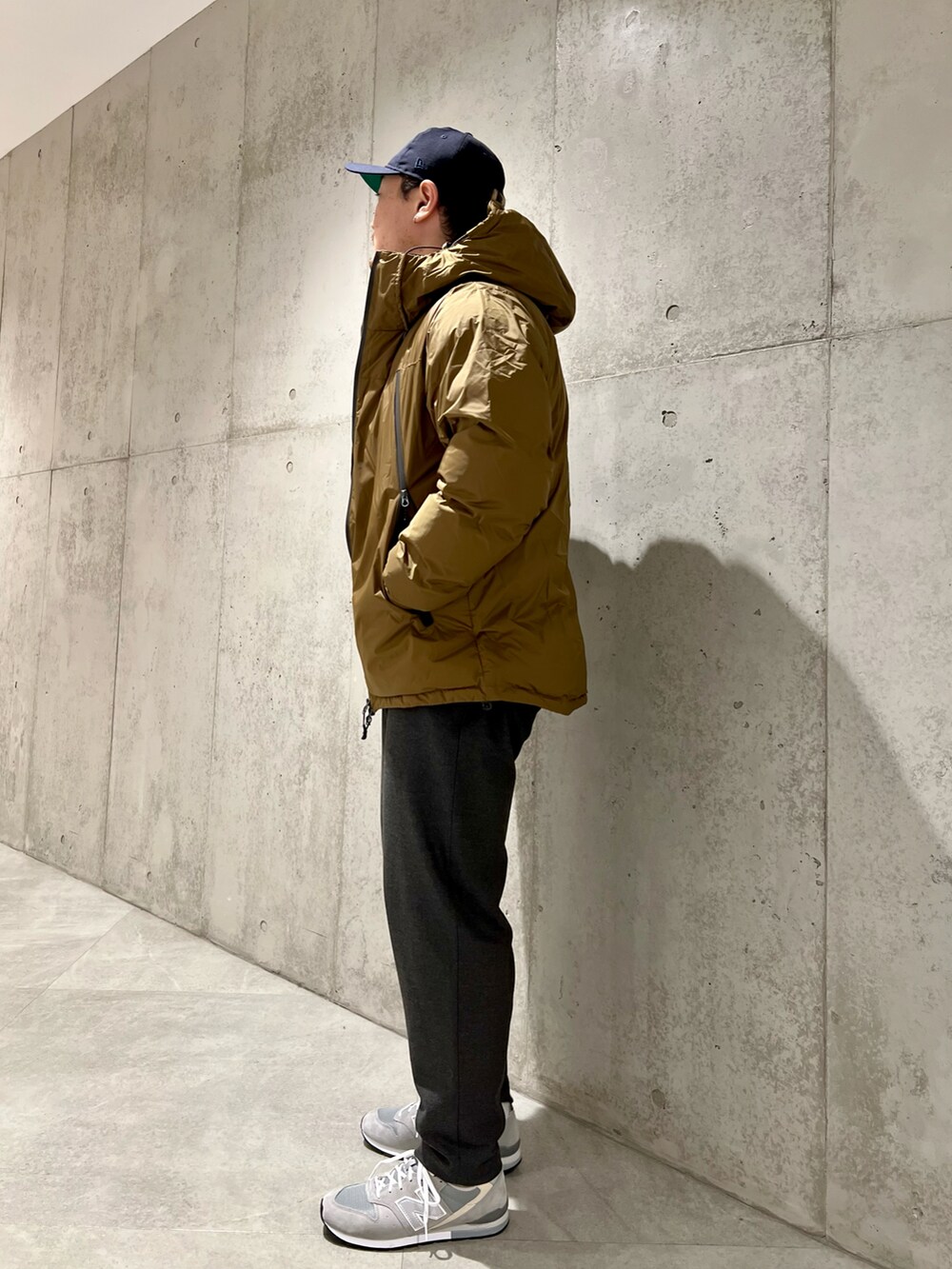 ベージュ系のダウンジャケット/コート、ブラウン系のニット/セーター、グレー系のその他パンツを着用したメンズの冬コーディネートの2枚目の写真