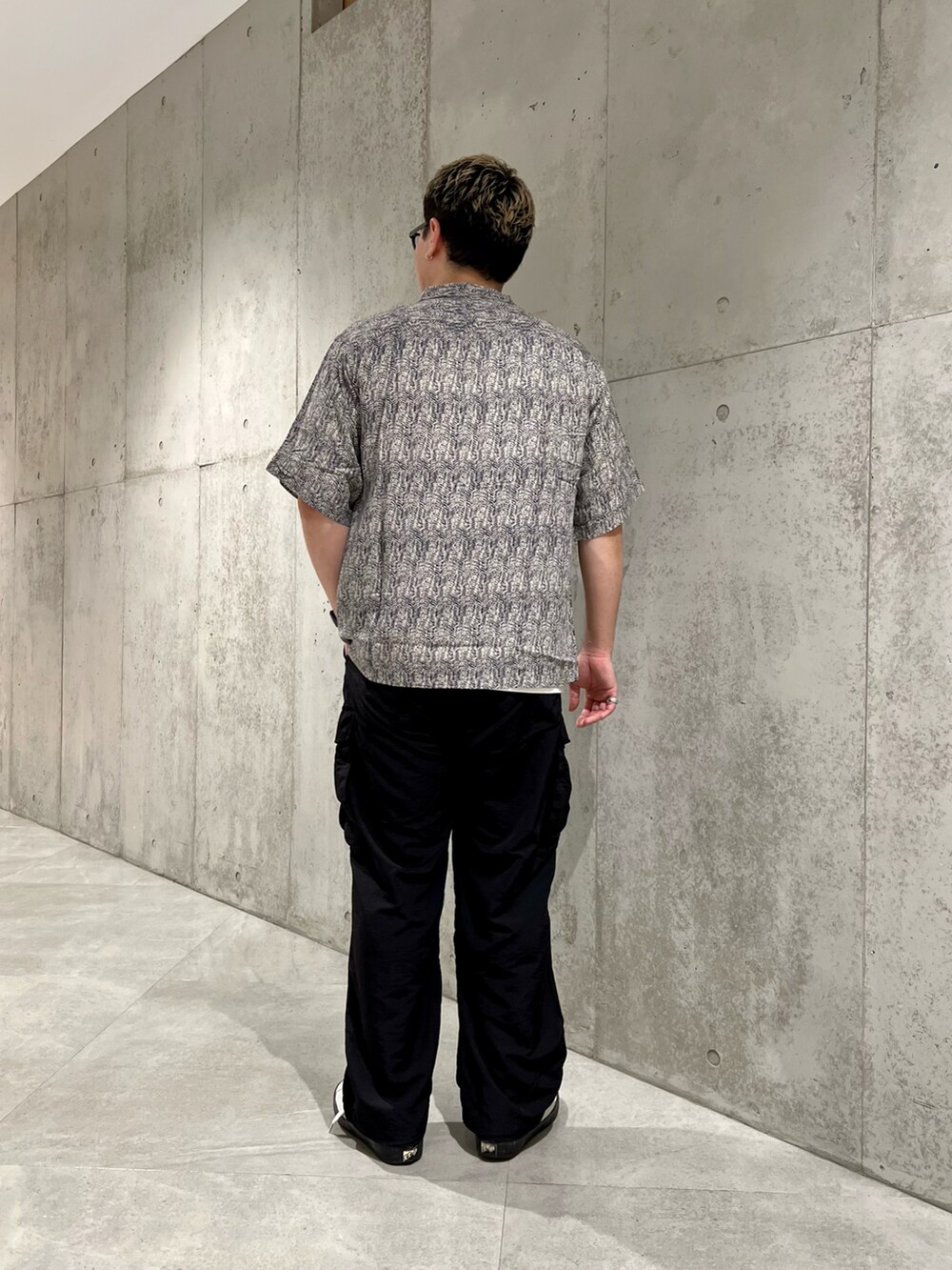 ホワイト系のスニーカー、ブラック系のその他パンツ、ホワイト系のTシャツ/カットソーを着用したメンズの夏コーディネートの4枚目の写真