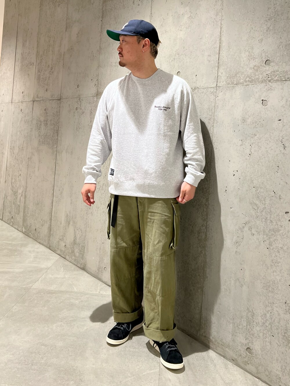 グリーン系のカーゴパンツ、ブルー系のブルゾン、グレー系のスウェットを着用したメンズの秋コーディネートの3枚目の写真