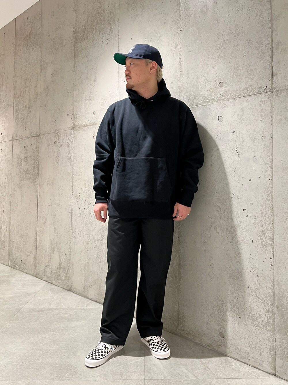 ブラック系のパーカー、ブラック系のチノパンツ、ブラック系のスニーカーを着用したメンズの秋コーディネートの3枚目の写真