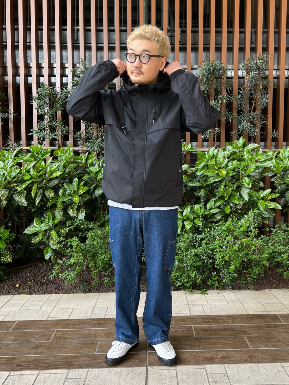 ブラック系のマウンテンパーカー、ブルー系のデニムパンツ、ホワイト系のTシャツ/カットソーを着用したメンズの春コーディネートの2枚目の写真