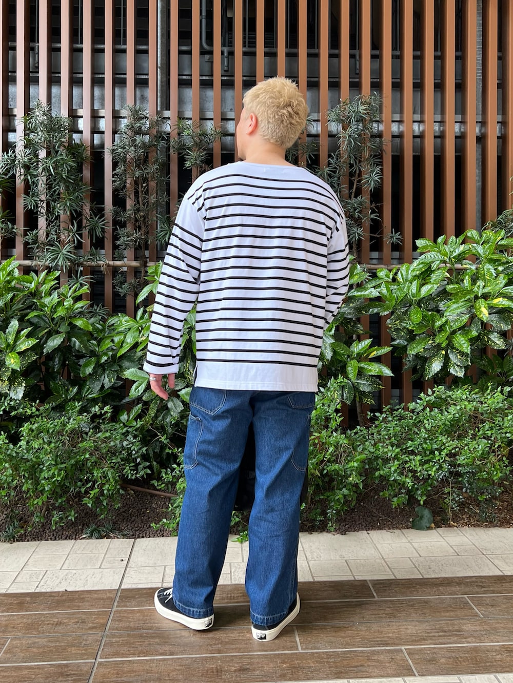 ブラック系のTシャツ/カットソー、ブルー系のデニムパンツ、ブラック系のバックパック/リュックを着用したメンズの春コーディネートの5枚目の写真