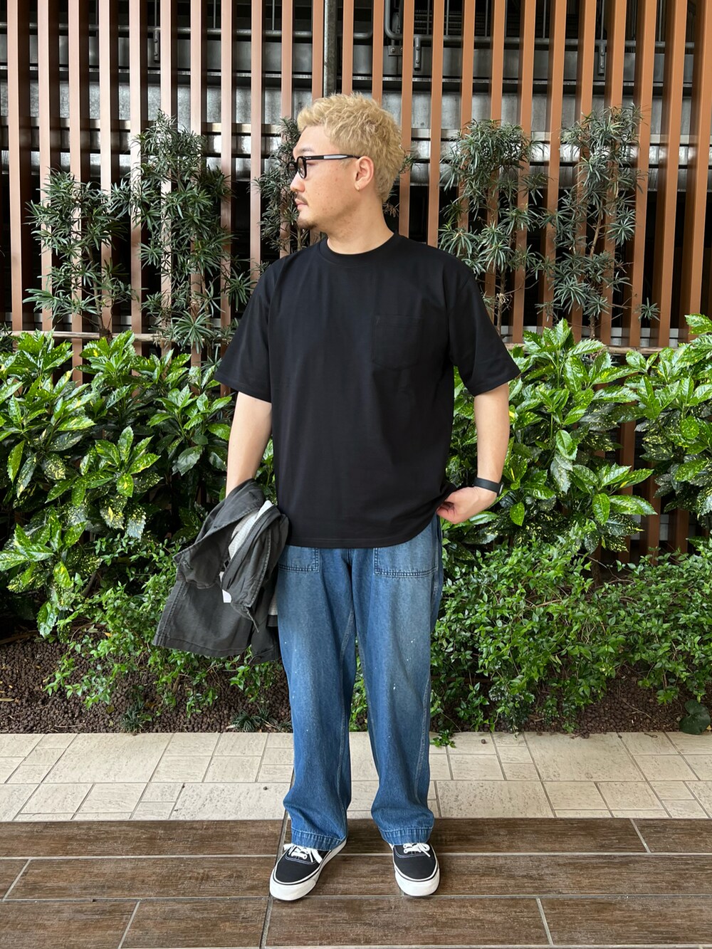 ブラック系のカバーオール、ブラック系のTシャツ/カットソー、ブラック系のスニーカーを着用したメンズの春コーディネートの2枚目の写真