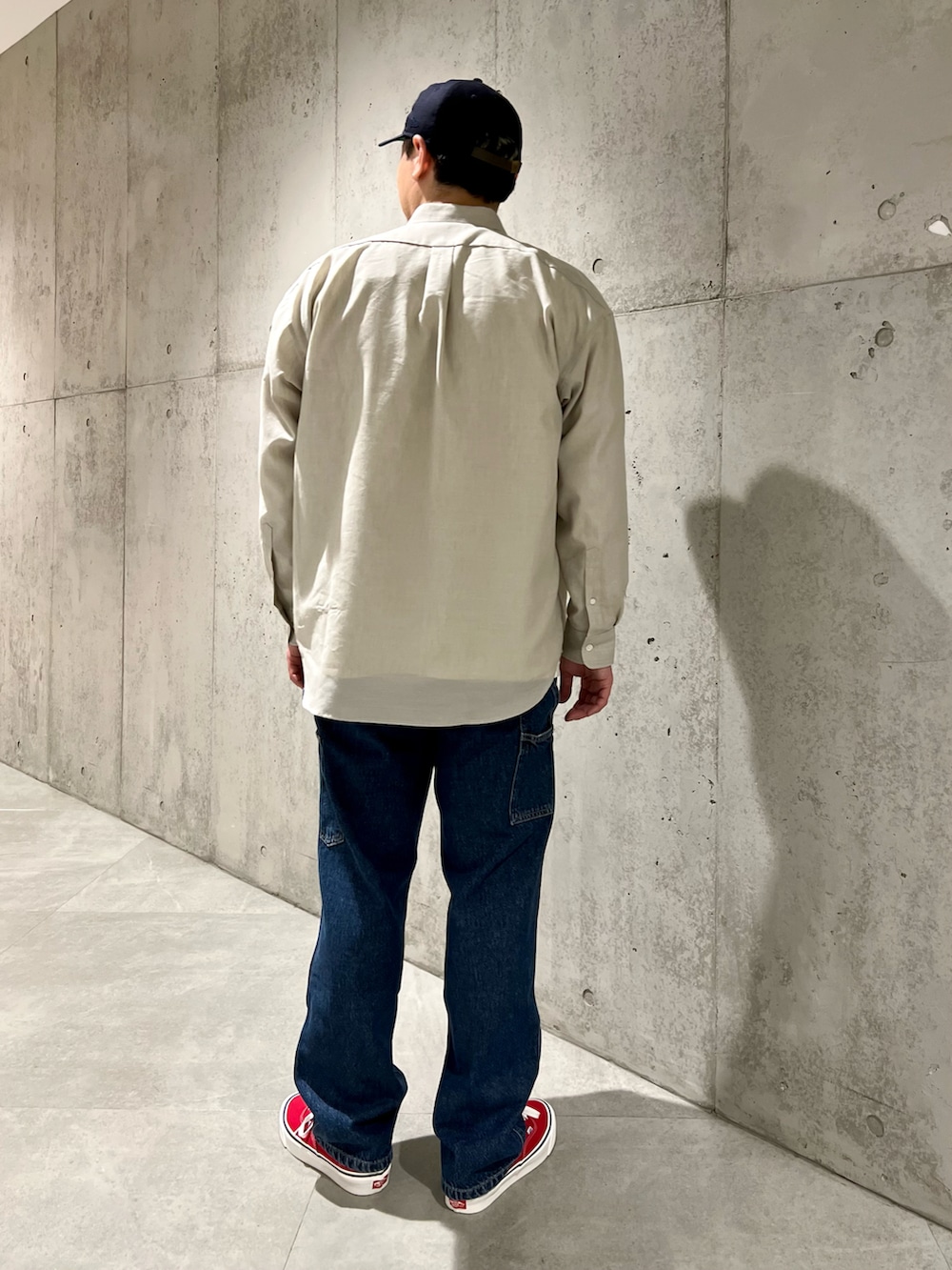 レッド系のスニーカー、ベージュ系のシャツ/ブラウス、ホワイト系のTシャツ/カットソーを着用したメンズの春コーディネートの4枚目の写真