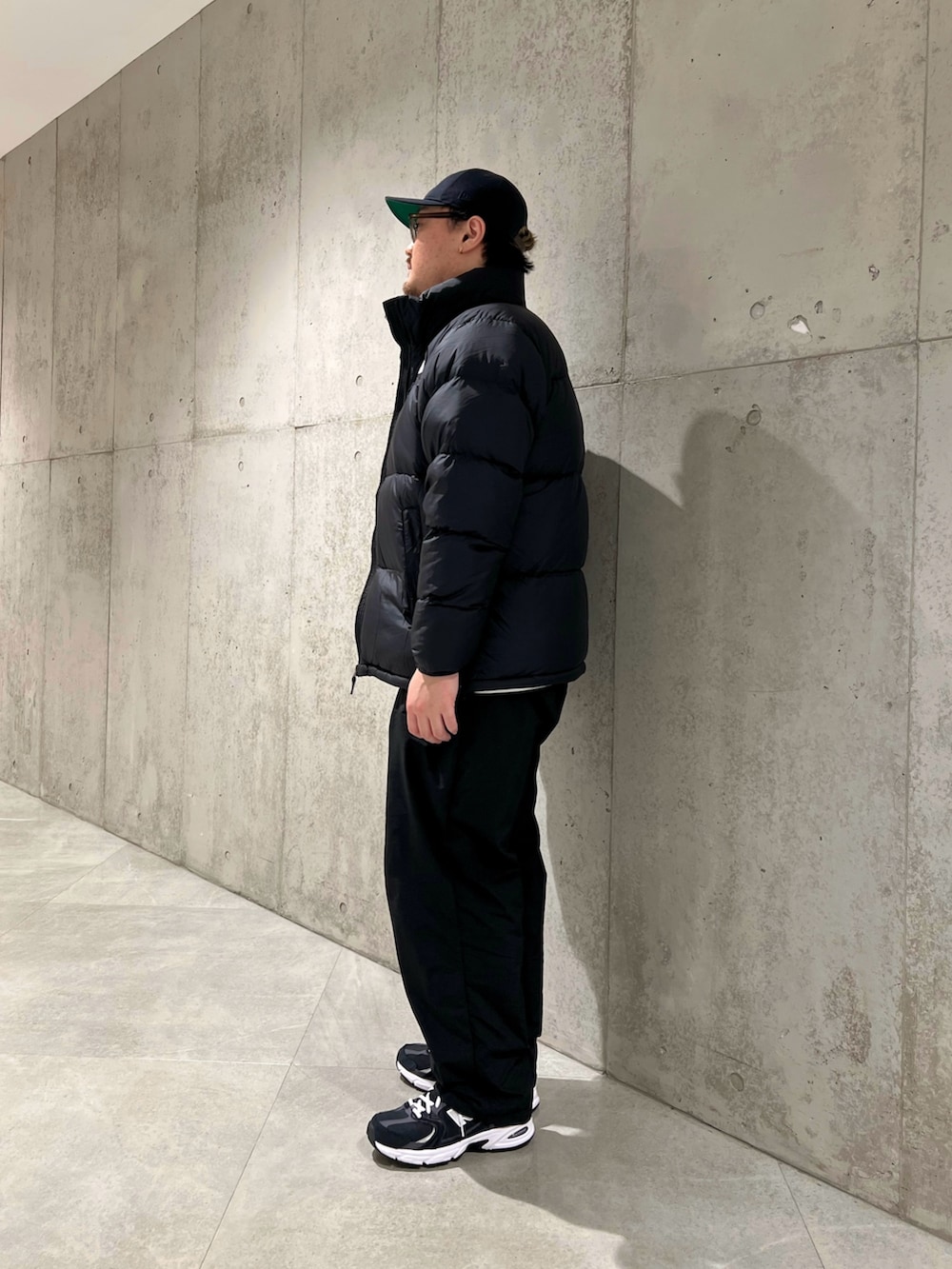 ブラック系のダウンジャケット/コート、ブラック系のパンツ、ブラック系のスニーカーを着用したメンズの秋コーディネートの2枚目の写真
