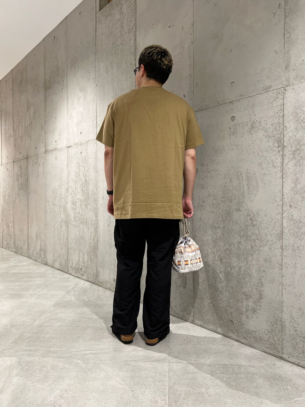 ベージュ系のTシャツ/カットソー、グレー系のショルダーバッグ、ブラック系のその他パンツを着用したメンズの夏コーディネートの4枚目の写真