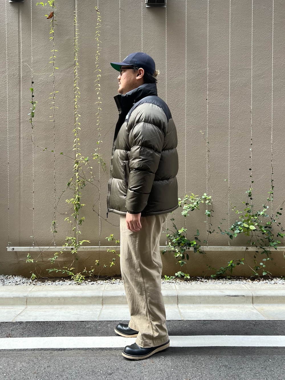 グリーン系のダウンジャケット/コート、ブラック系のブーツを着用したメンズの秋コーディネートの2枚目の写真