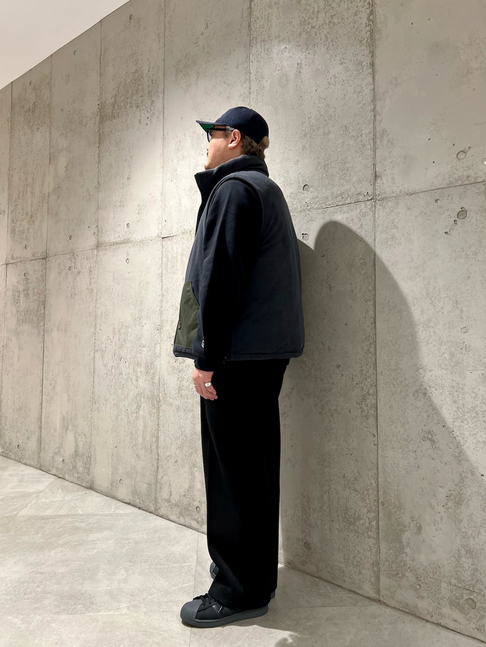 グリーン系のダウンベスト、ブラック系のその他パンツ、ブラック系のスウェットを着用したメンズの秋コーディネートの4枚目の写真