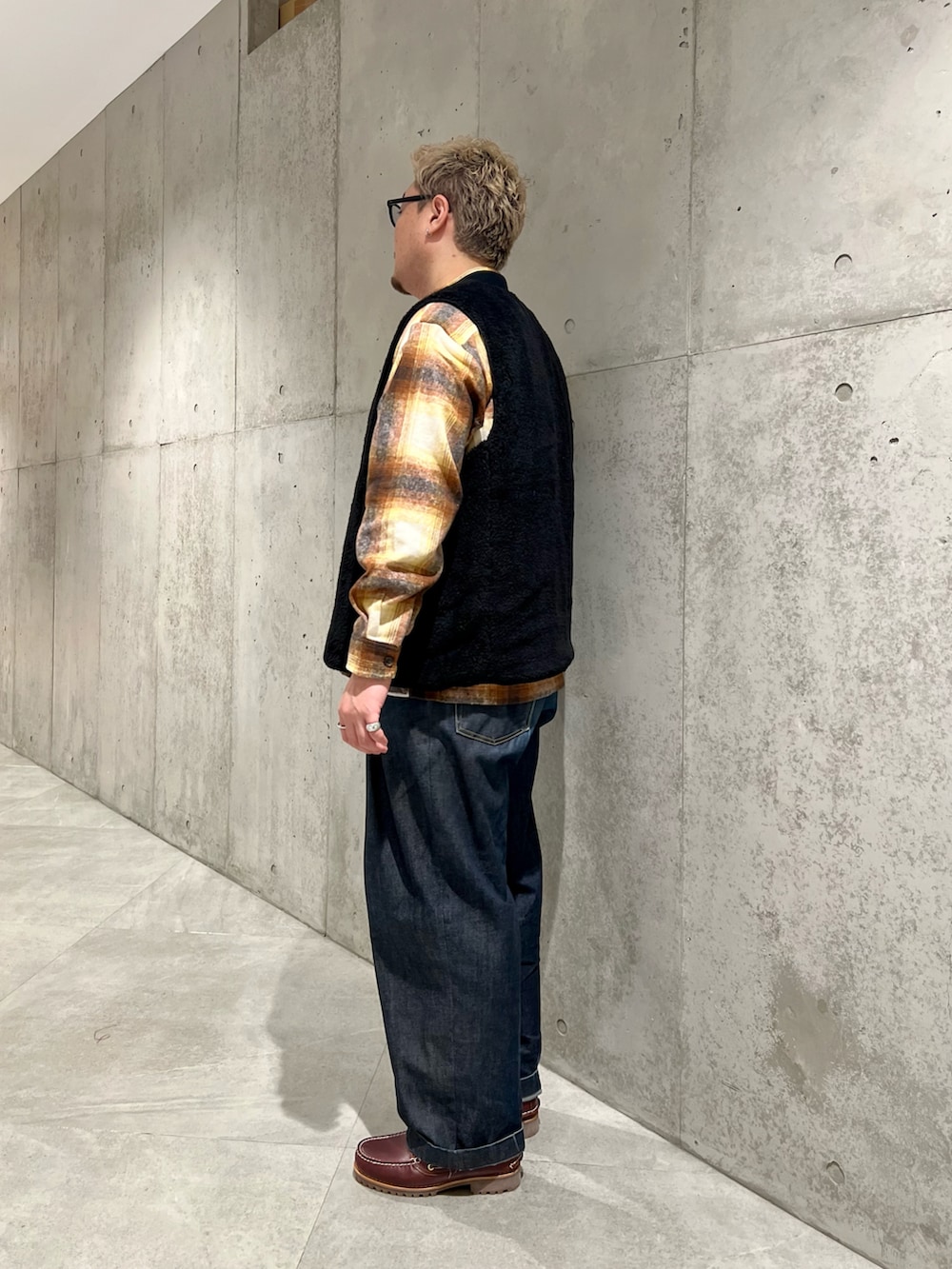 ブラック系のその他アウター、ブルー系のデニムパンツ、レッド系のモカシン/デッキシューズを着用したメンズの秋コーディネートの2枚目の写真