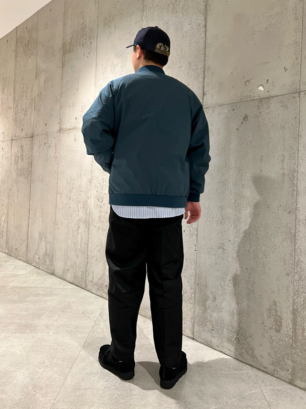 ブルー系のブルゾン、ブラック系のチノパンツ、ブルー系のシャツ/ブラウスを着用したメンズの冬コーディネートの4枚目の写真