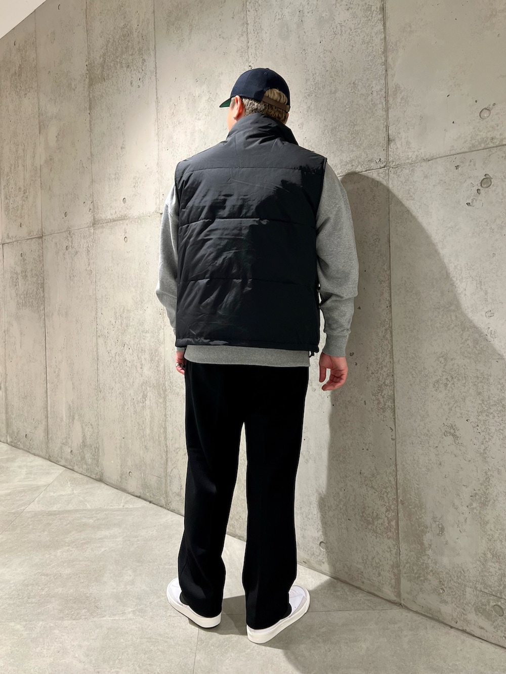 ブラック系のダウンベスト、グレー系のスウェット、ブラック系のその他パンツを着用したメンズの秋コーディネートの3枚目の写真