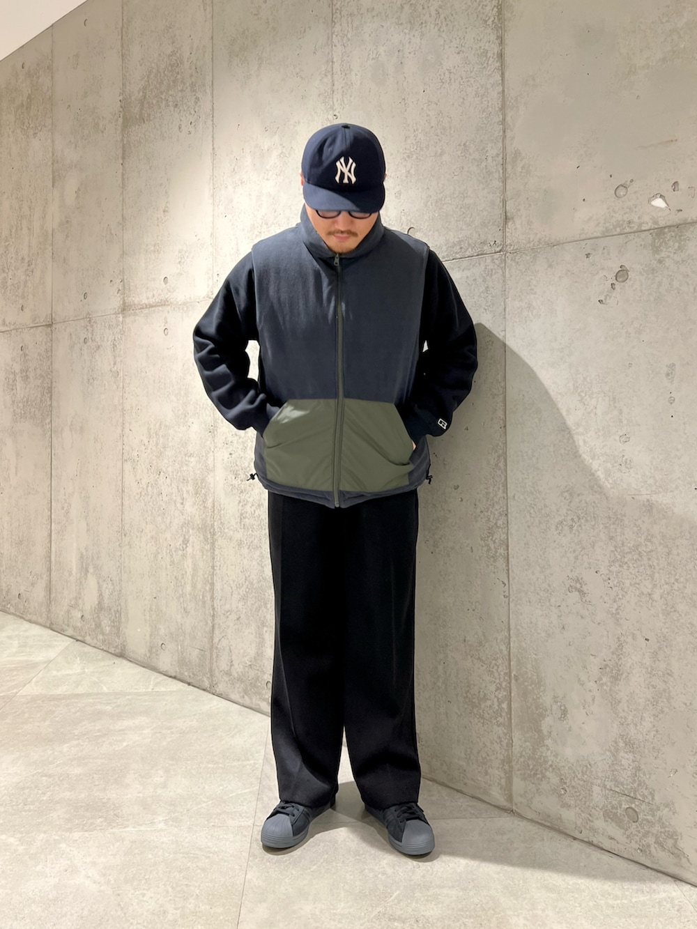 グリーン系のダウンベスト、ブラック系のその他パンツ、ブラック系のスウェットを着用したメンズの秋コーディネートの2枚目の写真