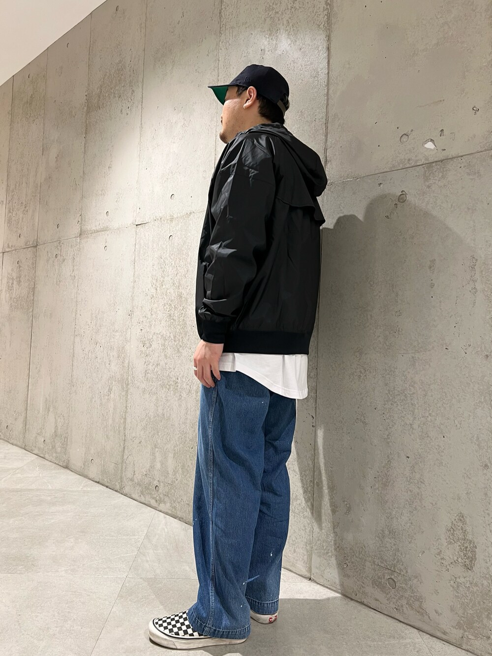 ブルー系のデニムパンツ、ブラック系のブルゾン、ブラック系のTシャツ/カットソーを着用したメンズの春コーディネートの3枚目の写真