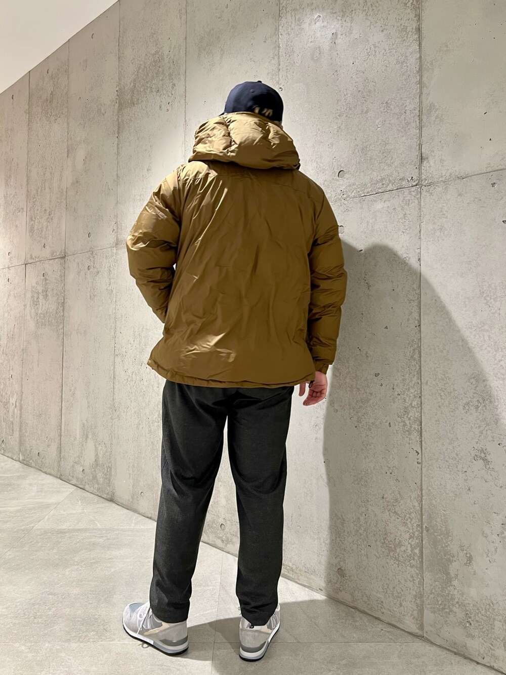 ベージュ系のダウンジャケット/コート、ブラウン系のニット/セーター、グレー系のその他パンツを着用したメンズの冬コーディネートの3枚目の写真