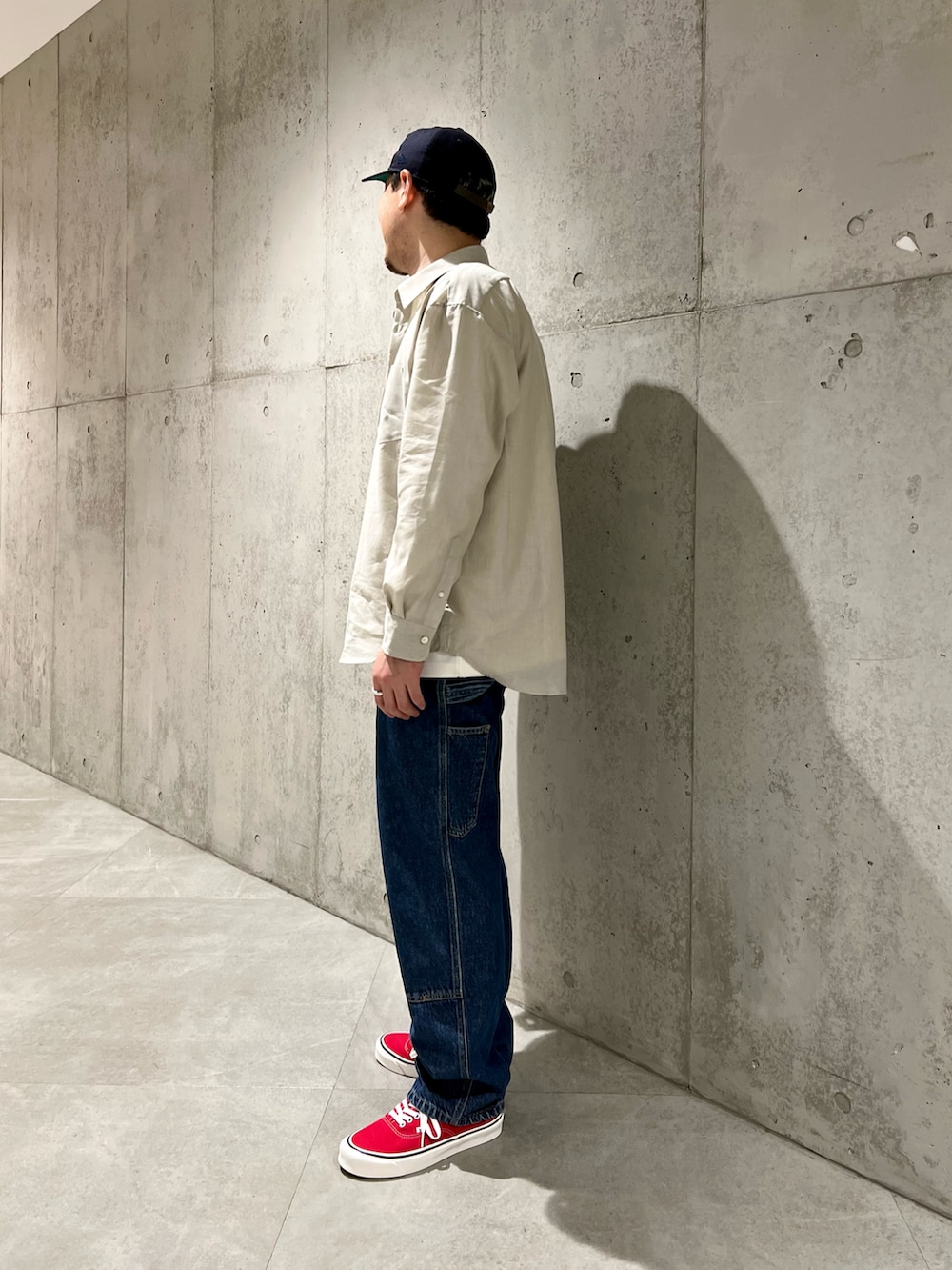 レッド系のスニーカー、ベージュ系のシャツ/ブラウス、ホワイト系のTシャツ/カットソーを着用したメンズの春コーディネートの3枚目の写真