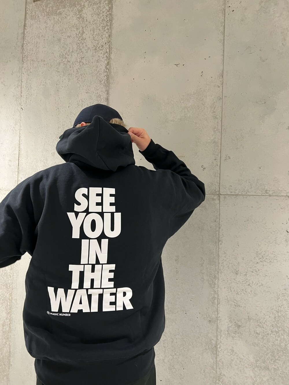 ブラック系のパーカー、ブラック系のチノパンツ、ブラック系のスニーカーを着用したメンズの秋コーディネートの2枚目の写真