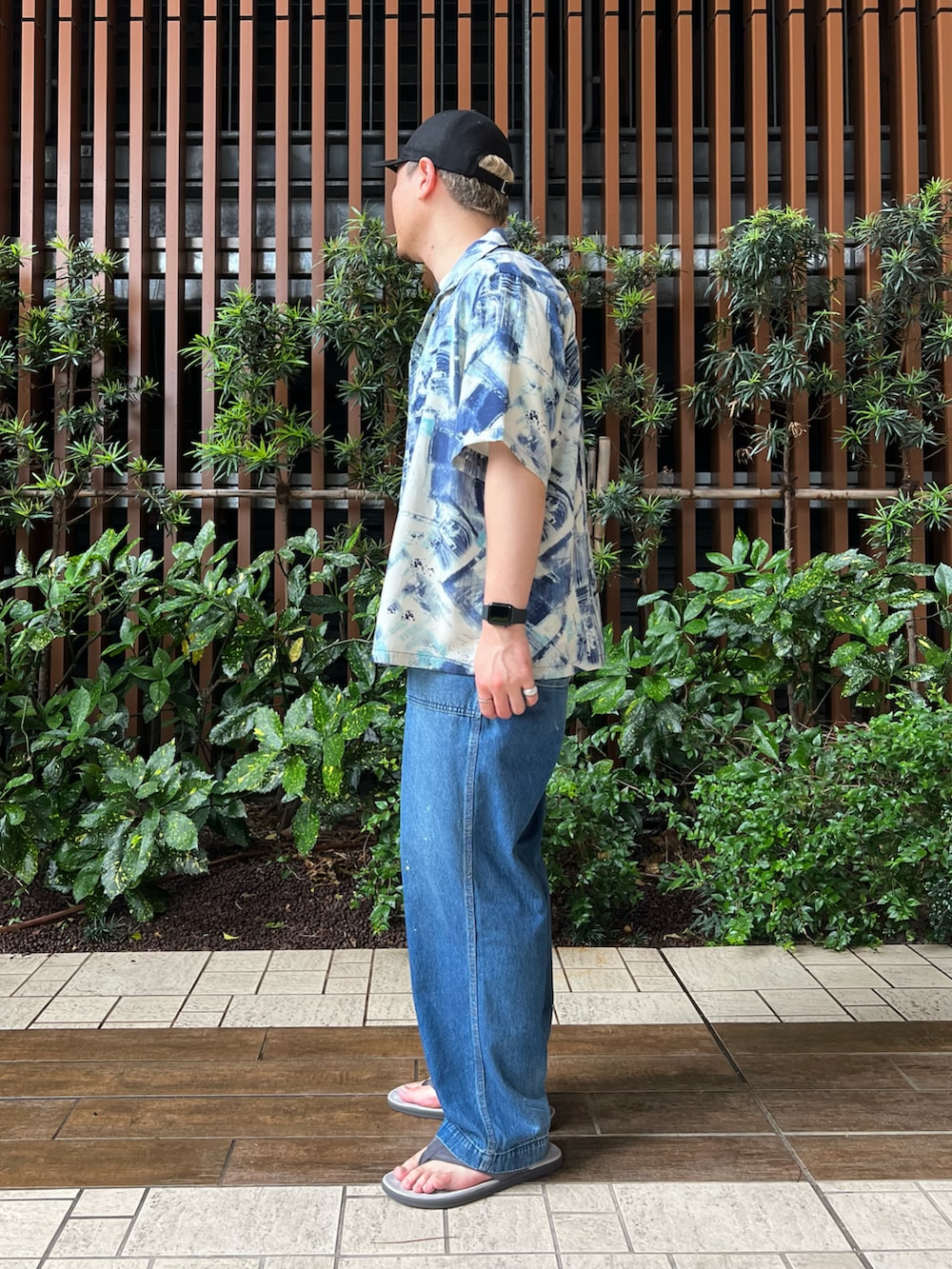 ブルー系のデニムパンツ、ホワイト系のTシャツ/カットソー、グレー系のサンダルを着用したメンズの夏コーディネートの3枚目の写真