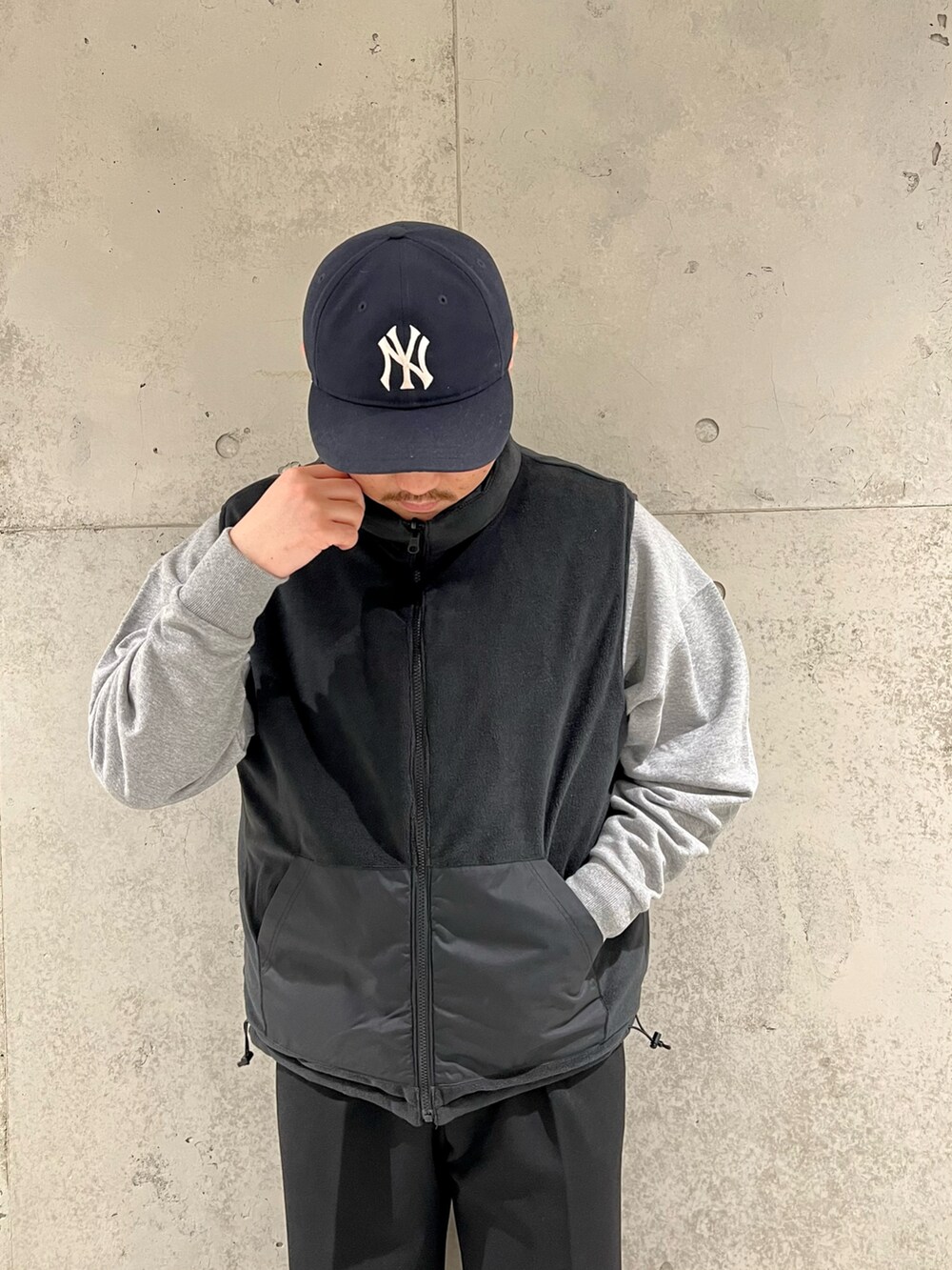 ブラック系のダウンベスト、グレー系のスウェット、ブラック系のその他パンツを着用したメンズの秋コーディネートの4枚目の写真