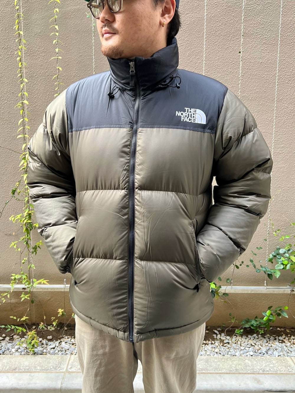 グリーン系のダウンジャケット/コート、ブラック系のブーツを着用したメンズの秋コーディネートの4枚目の写真