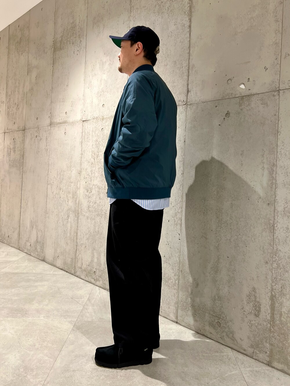 ブルー系のブルゾン、ブラック系のチノパンツ、ブルー系のシャツ/ブラウスを着用したメンズの冬コーディネートの3枚目の写真