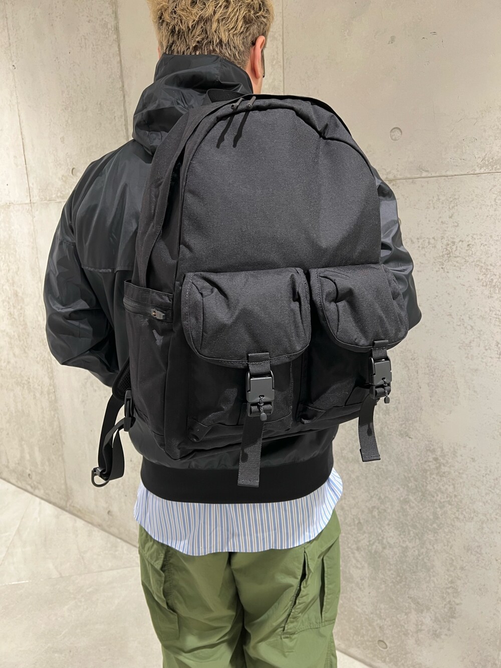 ブラック系のナイロンジャケット、ブルー系のシャツ/ブラウス、グリーン系のカーゴパンツを着用したメンズの冬コーディネートの4枚目の写真