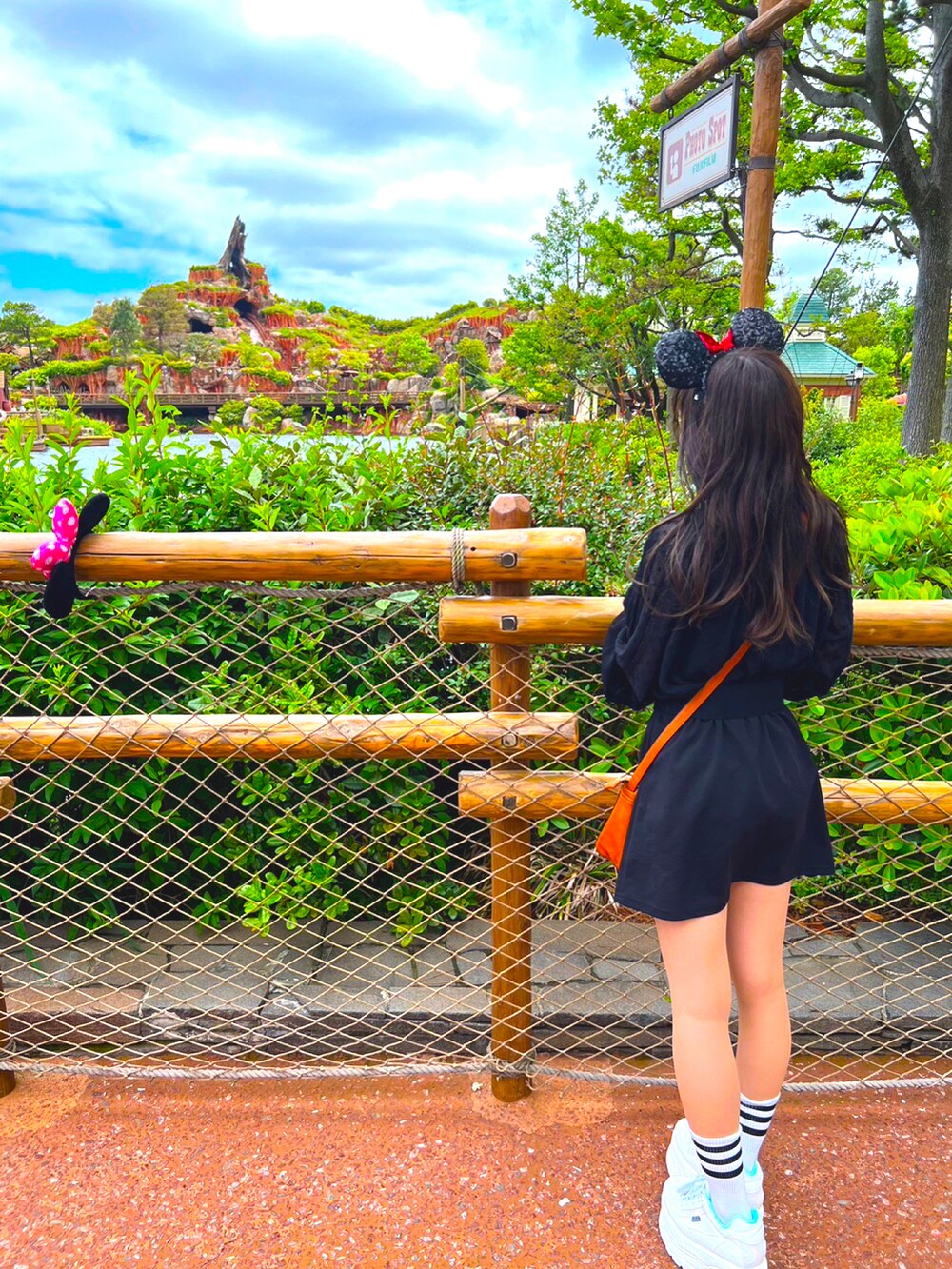 ホワイト系のスニーカー、ブラウン系のショルダーバッグ、ブラック系のスカートを着用したレディースの秋コーディネートの2枚目の写真