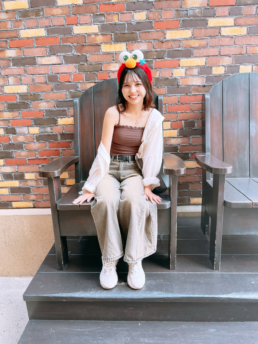 ブラウン系のキャミソール、ホワイト系のシャツ/ブラウス、ブラック系のデニムパンツを着用したレディースの秋コーディネートの2枚目の写真