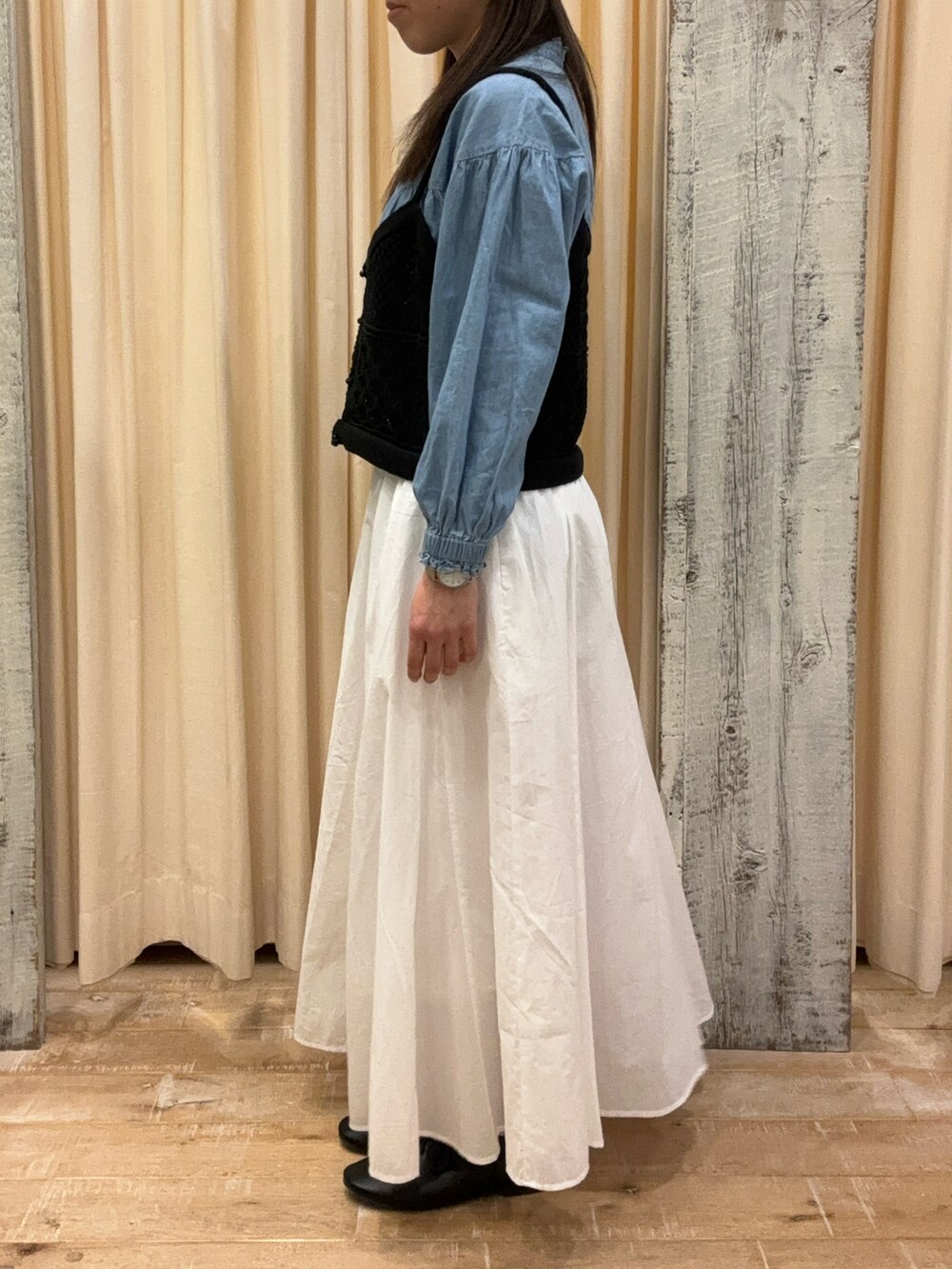 ホワイト系のスカート、ブラック系のトップス、ブルー系のシャツ/ブラウスを着用したレディースの春コーディネートの2枚目の写真