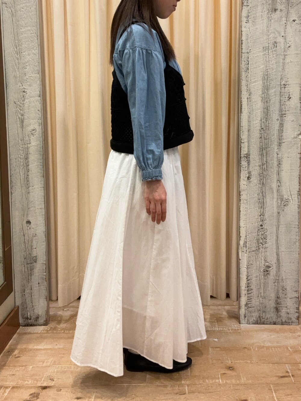 ホワイト系のスカート、ブラック系のトップス、ブルー系のシャツ/ブラウスを着用したレディースの春コーディネートの3枚目の写真