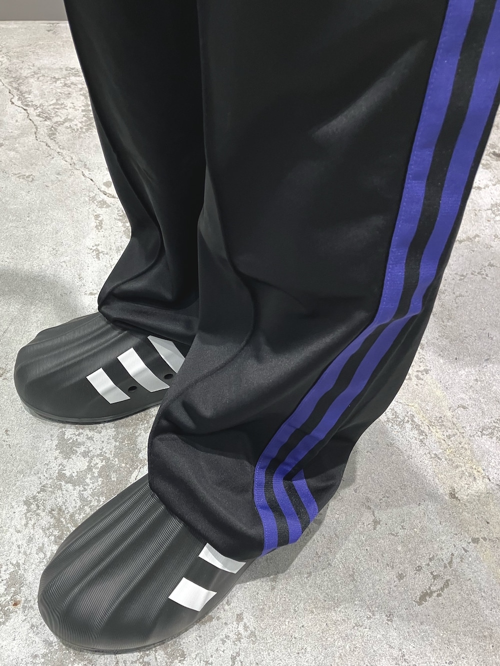 ブラック系のジャージ、ブラック系のスウェットパンツ、ブラック系のスニーカーを着用したメンズの秋コーディネートの2枚目の写真