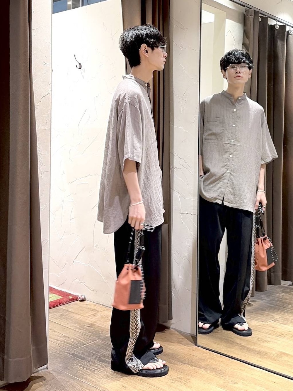 ブラック系のその他パンツ、オレンジ系のショルダーバッグ、グレー系のシャツ/ブラウスを着用したメンズの夏コーディネートの2枚目の写真