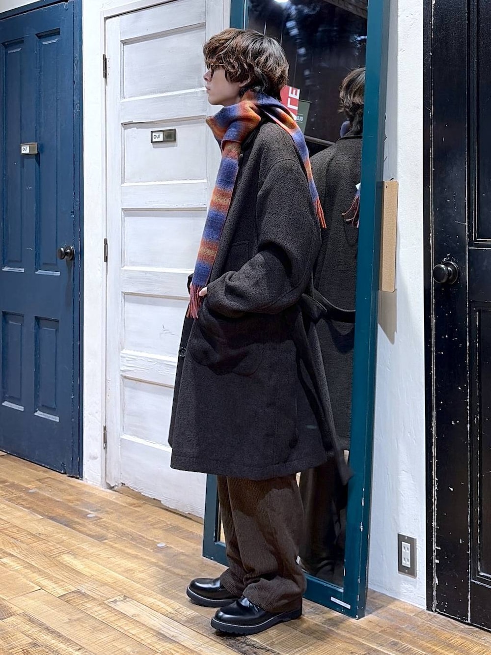 ブラック系のその他シューズ、レッド系のニット/セーター、ブラウン系のダウンジャケット/コートを着用したメンズの冬コーディネートの3枚目の写真