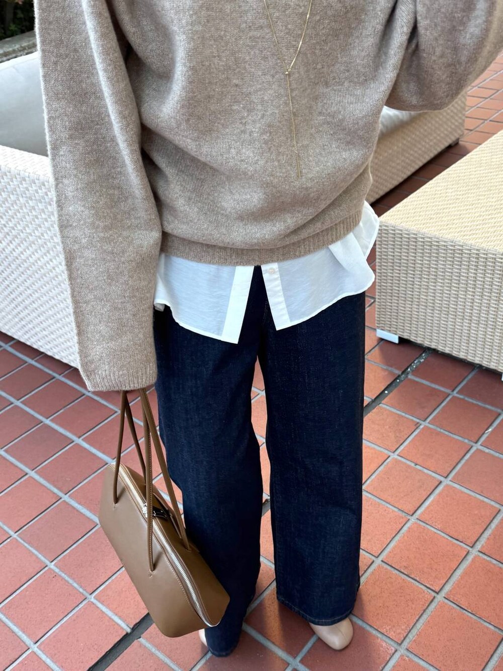 ブルー系のデニムパンツ、イエロー系のトートバッグ、ベージュ系のブーツを着用したレディースの冬コーディネートの7枚目の写真