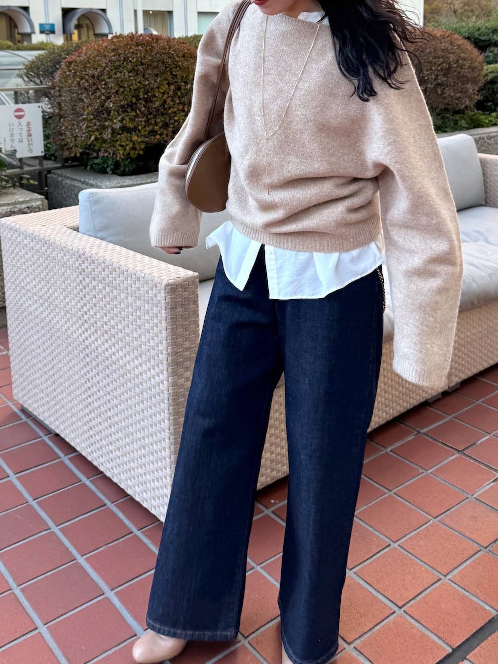 ブルー系のデニムパンツ、イエロー系のトートバッグ、ベージュ系のブーツを着用したレディースの冬コーディネートの2枚目の写真