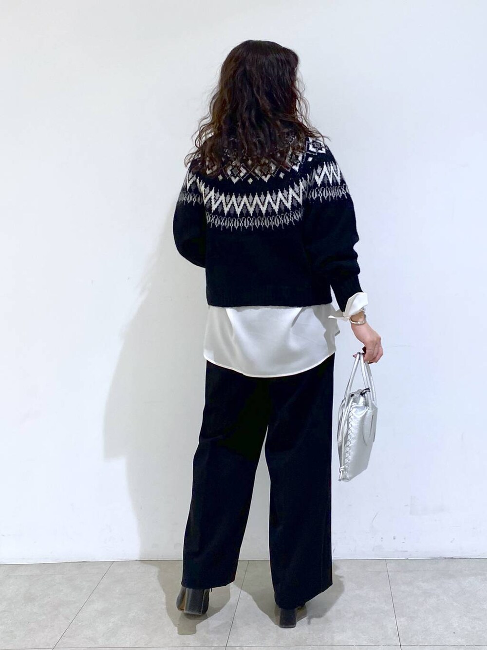 シルバー系のショルダーバッグ、ブラック系のTシャツ/カットソー、ホワイト系のシャツ/ブラウスを着用したレディースの冬コーディネートの4枚目の写真