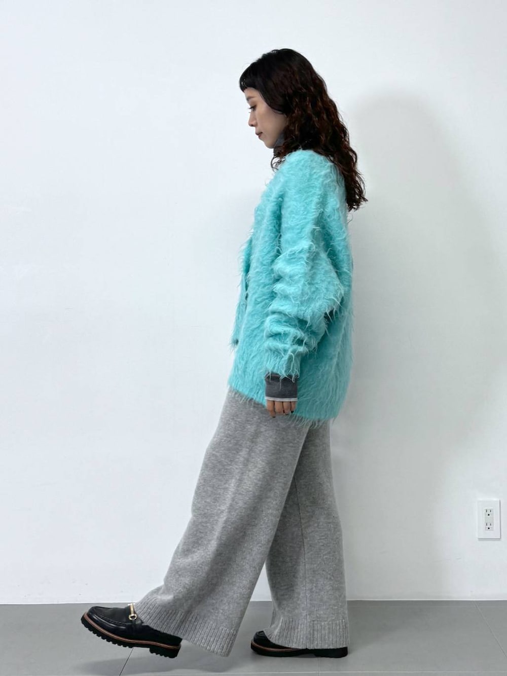 グレー系のその他パンツ、グレー系のニット/セーター、ブルー系のカーディガン/ボレロを着用したレディースの秋コーディネートの2枚目の写真