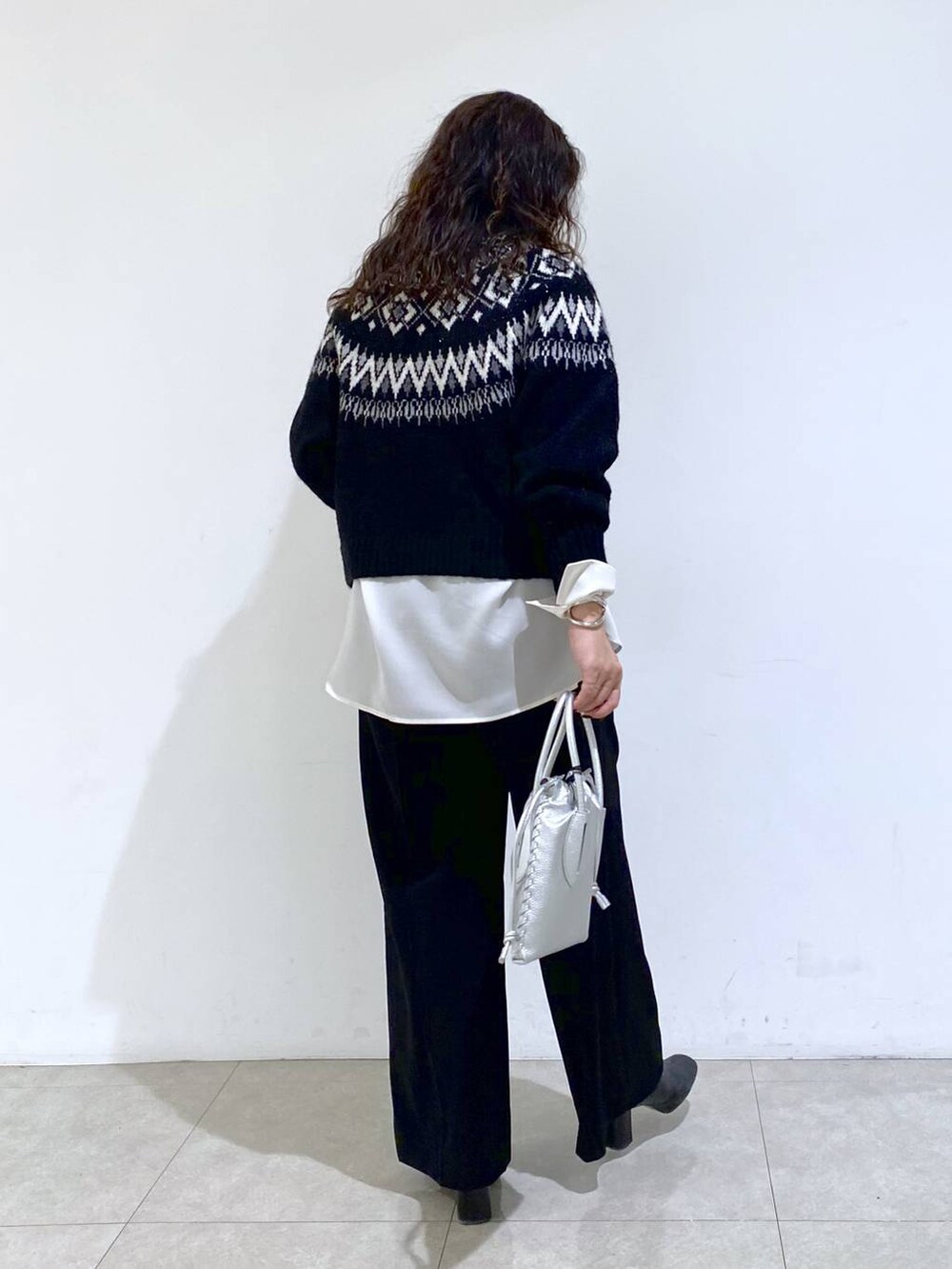 シルバー系のショルダーバッグ、ブラック系のTシャツ/カットソー、ホワイト系のシャツ/ブラウスを着用したレディースの冬コーディネートの5枚目の写真