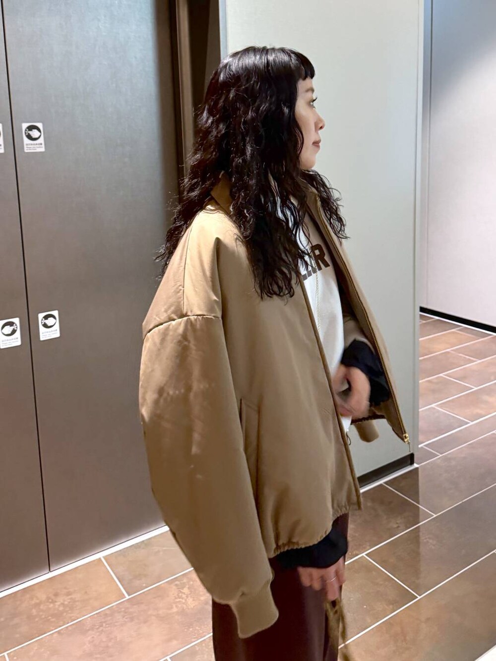 ベージュ系のブルゾン、ベージュ系のショルダーバッグ、ホワイト系のスウェットを着用したレディースの冬コーディネートの7枚目の写真